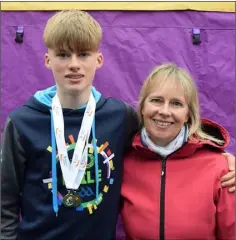  ??  ?? Myles Hewlett of United Striders with his mother, Emma, following his third place finish in the Under-16 boys’ race.