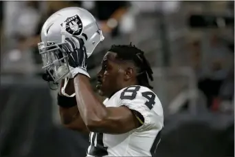  ?? RICK SCUTERI — THE ASSOCIATED PRESS ?? Raiders wide receiver Antonio Brown puts on his helmet prior to a game against the Cardinals on Aug. 15 in Glendale, Ariz.