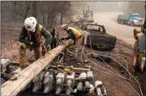  ?? JOEL ANGEL JUAREZ/ZUMA PRESS FILE PHOTOGRAPH ?? Pacific Gas and Electric Co. workers dissemble broken power lines on Nov. 15, 2018, after the Camp Fire ripped through Paradise.