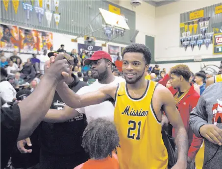  ?? D. Ross Cameron / Special to The Chronicle ?? Mission’s Niamey Harris basks in the congratula­tory hugs after his team defeated Vanden-Fairfield in the Division 3 final.