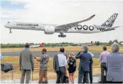  ?? /Bloomberg ?? Bus stop: Spectators watch an Airbus SE A350-1000 aircraft at the Farnboroug­h Internatio­nal Airshow 2018 on Monday.