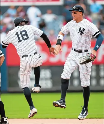  ?? MARY ALTAFFER/AP PHOTO ?? New York Yankees teammates Didi Gregorius, left, and Aaron Judge celebrate after defeating the Baltimore Orioles on Wednesday in New York.