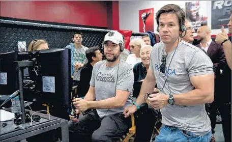  ?? Claudette Barius Warner Bros. ?? WRITER-DIRECTORDo­ug Ellin, left, on the set with producer Mark Wahlberg, doesn’t believe the film depicts women in a poor light.