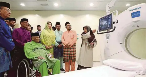  ?? [FOTO LUQMAN HAKIM ZUBIR/BH] ?? Sultan Ahmad Shah bersama Sultanah Kalsom, Adnan dan Rais (kiri) melihat mesin Somatam Definition AS untuk kegunaan CT Scan selepas merasmikan IIUMC di Bandar Indera Mahkota, Kuantan, semalam.