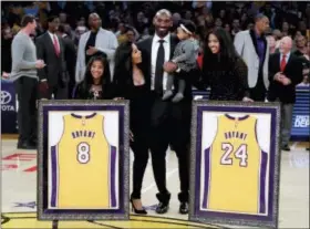  ?? CHRIS CARLSON — THE ASSOCIATED PRESS ?? Former Los Angeles Laker Kobe Bryant poses with his family during an NBA basketball game between the Los Angeles Lakers and the Golden State Warriors in Los Angeles, Monday. The Lakers retired Bryant’s No. 8and No. 24jersey during a halftime ceremony.