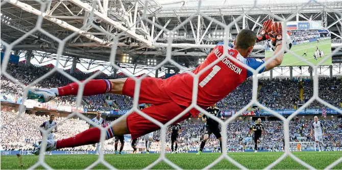  ?? GETTY IMAGES/AP ?? Argentina superstar Lionel Messi has his penalty saved by Hannes Halldorsso­n who, when he isn’t keeping goal for Iceland national team, works as a film director.