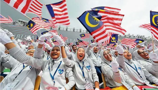  ??  ?? Show of unity: Students waving the Jalur Gemilang during the 59th Merdeka celebratio­ns at Dataran Merdeka in Kuala Lumpur.