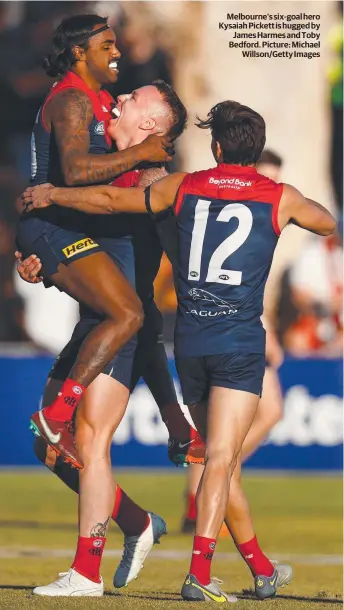  ?? ?? Melbourne’s six-goal hero Kysaiah Pickett is hugged by James Harmes and Toby Bedford. Picture: Michael Willson/Getty Images