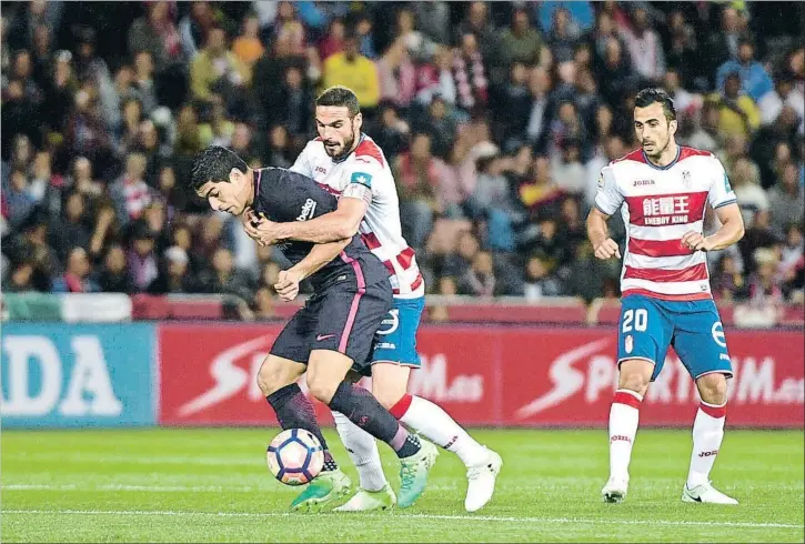  ?? MIGUEL ÁNGEL MOLINA / EFE ?? Luis Suárez intenta zafarse del marcaje pegajoso al que le sometió Lombán durante todo el partido