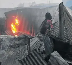  ?? / VELI NHLAPO ?? A resident watches as his shack goes up in smoke in Alexandra, Johannesbu­rg, yesterday.