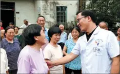  ?? ZHANG DUAN /XINHUA ?? Zhang Jianming (front right) bids farewell to villagers in Xujia village.