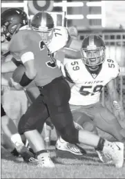  ?? PILOT PHOTO/RON HARAMIA ?? Triton’s Landon Lemler (58) eyes the running back during a game earlier this season. The Trojans hit the road for their sectional semifinal game Friday.