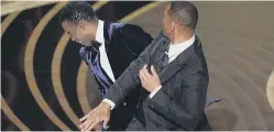  ?? ?? Slap unhappy! Will Smith, right, hits presenter Chris Rock on stage while presenting the award for best documentar­y feature at the Oscars. (AP Photo/Chris Pizzello)