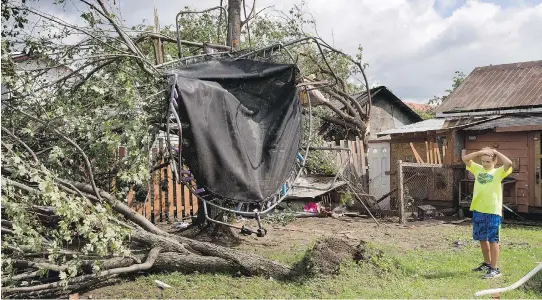  ?? RYAN REMIORZ /THE CANADIAN PRESS ?? Emile Turcotte’s trampoline was hanging from a tree after a Category F1 tornado passed through Lachute, Que., 110 km east of Ottawa, on Wednesday.