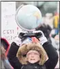  ??  ?? A woman holds up a globe demanding action on climate change during a demonstrat­ion in Montreal, Quebec,Canada on Dec 8. (AP)