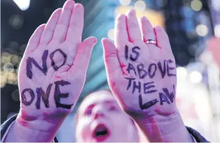  ?? PHOTO: REUTERS ?? Seeking justice . . . People take part in the ‘‘Noone is Above the Law’’ protest in New York yesterday, gathering in Times Square and chanting slogans including ‘‘Hands off Mueller’’ before marching downtown.