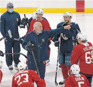  ?? DAVID SANTIAGO THE ASSOCIATED PRESS FILE PHOTO ?? A partially masked Florida Panthers head coach Joel Quennevill­e gives instructio­n to his team during training camp in preparatio­n for the 2021 NHL season Sunday in Sunrise, Fla.