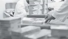  ??  ?? A pharmacist handles boxes of contracept­ive pills at a pharmacy in Niamey, Niger.