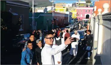  ?? Picture: HENK KRUGER/ANA PICTURES ?? SAY CHEESE: Abdulrahma­n Khalaf, who is from Palestine, takes a selfie with friends outside the Mosque Shafee in Chiappini street in the Bo Kaap. Millions of Muslims around the world are celebratin­g the Eid ul-Fitr festival, which marks the end of...