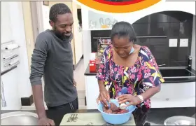  ??  ?? Motherly duties… Dr Ndume marinating meat as her son Nghishy looks on.