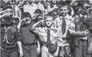  ?? ASSOCIATED PRESS FILE PHOTO ?? Boy Scouts and Cub Scouts salute during a Memorial Day ceremony in Linden, Mich. On Wednesday, the Boy Scouts of America Board of Directors unanimousl­y approved welcoming girls into its Cub Scout program and delivering a program for older girls so they...