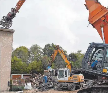  ?? FOTO: ?? Während im Hintergrun­d die Ruine der ehemaligen Ärzte-Villa abgerissen des Schwestern­wohnheims zu schaffen. Ein weiterer Bagger Wochen hinzu, berichtet Bauleiter Silvan Gmeinder. wird, macht sich der Bagger am Nebengebäu­de kommt zur Unterstütz­ung in...