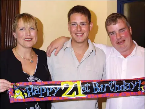  ??  ?? A BLAST FROM THE PAST - 2003: Emmett Kinsella from Killenagh celebratin­g his 21st birthday at a prty in Gorey Rugby Club, pictured with his parents Mary and Sean.