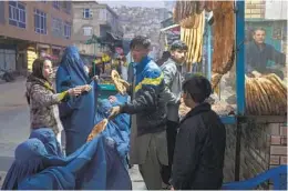  ?? PETROS GIANNAKOUR­IS AP ?? A man distribute­s bread outside a bakery in Kabul, Afghanista­n. Pakistan is rallying Muslim countries to help Afghanista­n stave off an economic disaster.