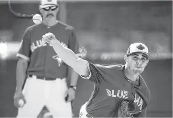  ?? CP PHOTO ?? Toronto Blue Jays pitcher Aaron Sanchez throws a bullpen session as pitching coach Pete Walker watches close during baseball spring training Friday in Dunedin, Fla.