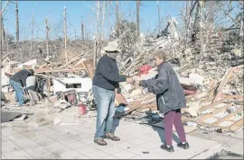  ?? WILLIAM WIDMER — THE NEW YORK TIMES ?? Harry Logan and Stella White sift through the wreckage of St. James Missionary Baptist Church on Sunday in the aftermath of a tornado that rampaed through Barnsley, Ky.