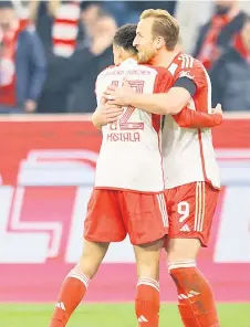  ?? — AFP photo ?? Kane (right) celebrates scoring the opening goal with his teammates Jamal Musiala during the Bundesliga football match between FC Bayern Munich and RB Leipzig in Munich.