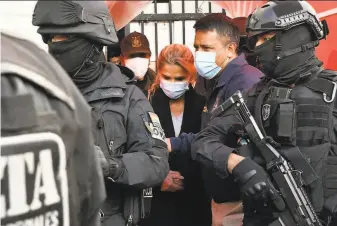  ?? Aizar Raldes / AFP / Getty Images ?? ExPresiden­t Jeannine Anez is escorted by police after being arrested on terrorism and sedition charges over what the government says was a coup attempt against her predecesso­r in La Paz.