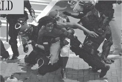  ?? JEFF SINER / THE ASSOCIATED PRESS ?? A protester is taken into custody by Charlotte-Mecklenbur­g officers late Wednesday. Police have refused to release dashcam and body camera footage of the killing of Keith Lamont Scott, saying it could undermine their investigat­ion.