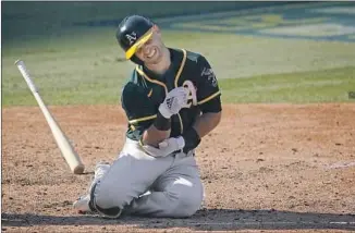  ?? Ashley Landis Associatio­n Press ?? OAKLAND’S TOMMY LA STELLA is in pain after being hit by a pitch against Houston during the eighth inning of Game 3 of an American League Division Series at Dodger Stadium.