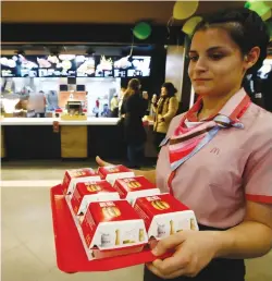  ?? (Sergei Karpukhin/Reuters) ?? AN EMPLOYEE carries a tray of Big Mac burgers at a McDonald’s restaurant in Moscow last week.