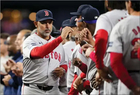  ?? LINDSEY WASSON — THE ASSOCIATED PRESS ?? Boston Red Sox manager Alex Cora greets his players during introducti­ons before the team’s opening day game against the Seattle Mariners on Thursday night in Seattle.