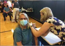  ??  ?? Debbie Sparks smiles beneath her mask as Trish Stephan administer­s her vaccine shot at Friday’s clinic.