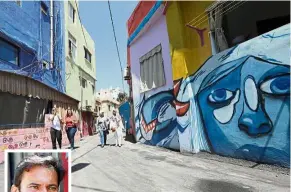  ?? — AFP ?? Colourful street: People walking past houses, painted as part of the ‘Ouzville’ project, helmed by Nasser (inset) in Beirut’s Ouzai neighbourh­ood.