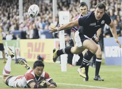  ??  ?? 2 Scotland’s John Hardie plays a pass in the buildup to his try in the 45- 10 victory over a tiring Japan side during the 2015 Rugby World Cup.