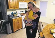  ?? Charles Krupa / Associated Press ?? Cancer survivor Christine Ells embraces son Jameson, 1, in Whitman, Mass.