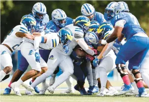  ?? BILLY SCHUERMAN /STAFF PHOTOS ?? A swarm of Delaware defenders stuff Hampton running back Tymere Robinson on Saturday at Armstrong Stadium.