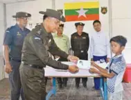  ?? AFPPIX ?? An immigratio­n official hands over an ID card to an unidentifi­ed Rohingya boy belonging to the returning family at the Taungpyole­twei repatriati­on camp in Maungdaw in this handout photo released by the Myanmar News Agency yesterday.