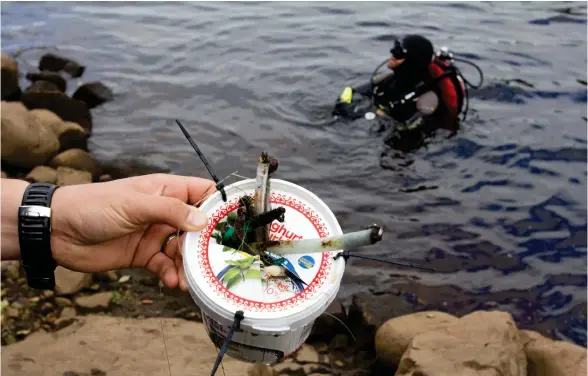  ?? Bild: JONATAN GERNES ?? STÄDNING. Hinkvis med skrot plockades upp ur det mörka vattnet av dykarna. Mest handlar det om fiskedrag och sänken som fastnat på botten.