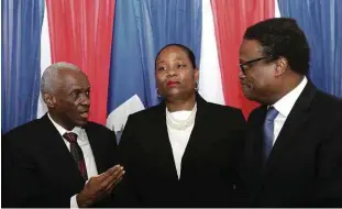  ?? Ralph Tedy - 25.abr.24/Reuters ?? Edgard Leblanc (esq.) e Fritz Belizaire (dir.) conversam com Regine Abraham após cerimônia, em Porto Príncipe, para instalar o conselho de transição no Haiti