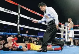  ?? Jeff Gross Getty Images ?? TEWA KIRAM receives a standing eight count after being knocked down by Lucas Matthysse, right, during Saturday night’s bout at The Forum.