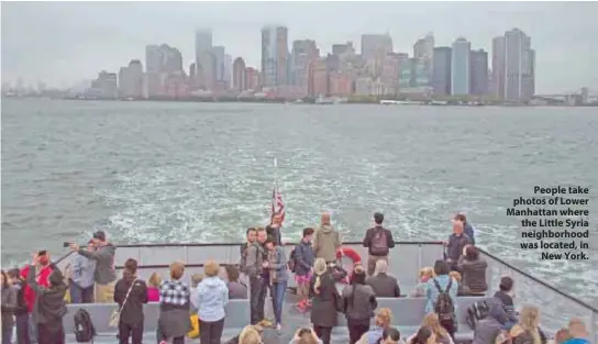  ??  ?? People take photos of Lower Manhattan where the Little Syria neighborho­od was located, in New York.