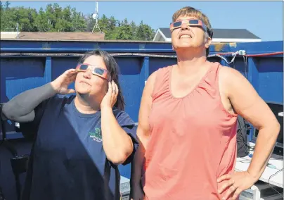  ?? DAVID JALA/CAPE BRETON POST ?? Two Rivers Wildlife Park employees Kelly Huntington, left, and Rosemary MacLean took advantage of the facility’s observator­y to check out Monday’s solar eclipse. They were able to look directly at the sun as they were wearing special glasses with a...