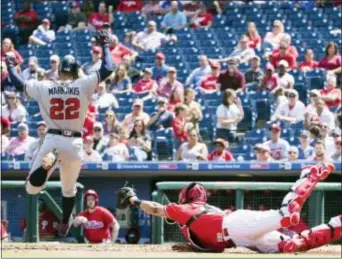  ?? CHRIS SZAGOLA — THE ASSOCIATED PRESS ?? Atlanta’s Nick Markakis, left, leaps away from the tag attempt by Phillies catcher Jorge Alfaro and scores during the third inning of the first game of Wednesday’s doublehead­er in Philadelph­ia.