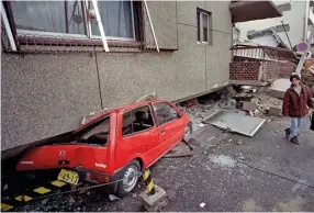  ??  ?? (ABOVE right) KOBE, JA PAN , 1995 A man walks past a collapsed home following one of Japan’s worst earthquake­s, which killed over 5000 people. Picture taken with a Nikon F90 and Nikkor 18mm f/3.5 lens