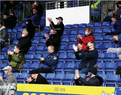  ??  ?? GOOD TO BE BACK: Ross County fans applaud their return to watch the game against Celtic yesterday — but the joy was short-lived as their team lost 5-0
